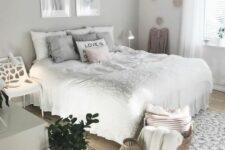 a cool neutral teen girl bedroom with a grey accent wall, a bed with neutral bedding, a white chair, a dresser, some artwork and a fluffy lamp
