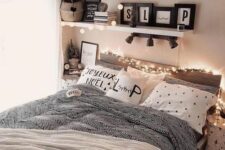 a cozy teen girl bedroom with a bed and printed bedding, shelves with lights and plants, books and magazines