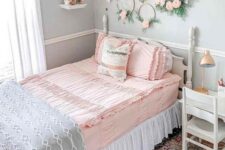 a romantic vintage teen bedroom with light blue walls, vintage neutral furniture, wreaths with blooms, a blue crystal chandelier and pastel bedding