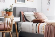 a stylish modern teen room with an upholstered bed, a white desk, a wooden chair, a gallery wall and cool hooks