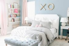 an airy teen girl bedroom with an ocean blue accent wall, open shelves in the corner, a white bed with neutral bedding, a powder blue upholstered bench