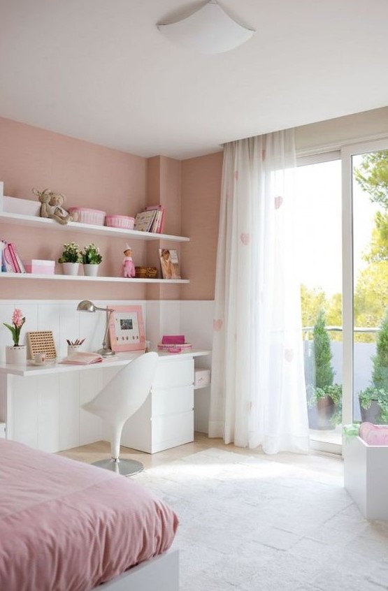 a contemporary pink teen bedroom with a white desk, heart print curtains, open shelves and a bed with pink bedding