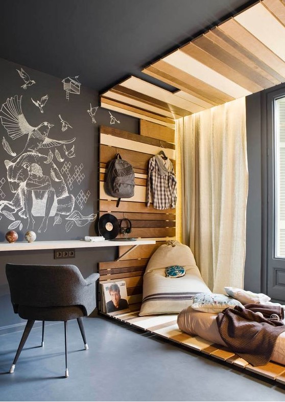 a contemporary teenage room with a bright wooden arch, a floating desk, a grey chair and a chalkboard wall