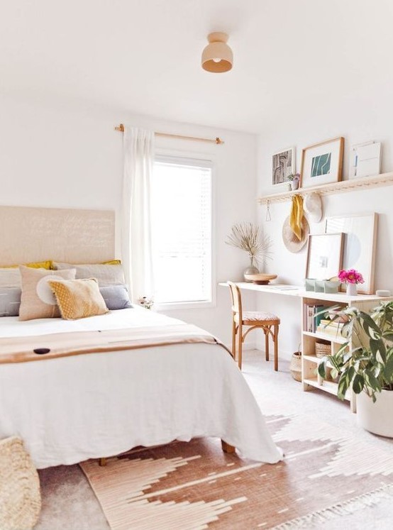 a lovely light-filled teen bedroom with a bed, a small desk with storage, a ledge with artworks and potted plants