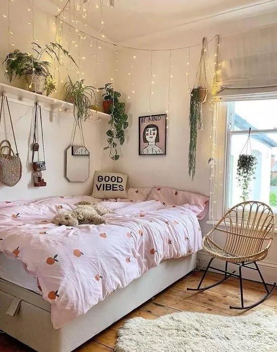 a pretty teen room with a storage bed, a shelf with lots of potted plants and lights hanging over the bed, pretty bedding and art