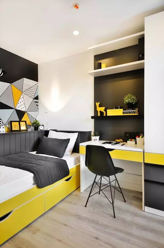 a small and brigth teen room with a built-in desk and shelves, a bold yellow bed with black and white bedding and bold art on the wall