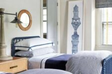 a stylish navy and white traditional shared teen bedroom with blue beds, wooden furniture and a printed ceiling