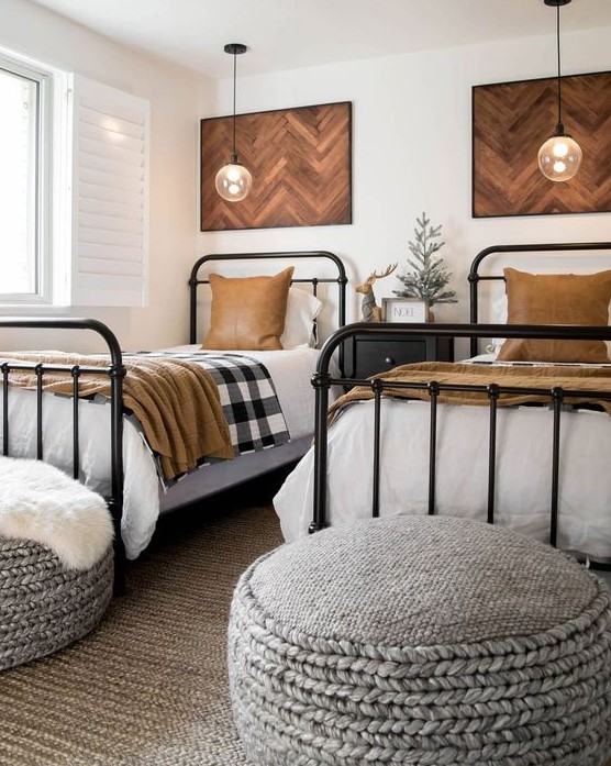 a stylish shared boy bedroom with chevron artworks, metal beds, knit ottomans and pendant lamps