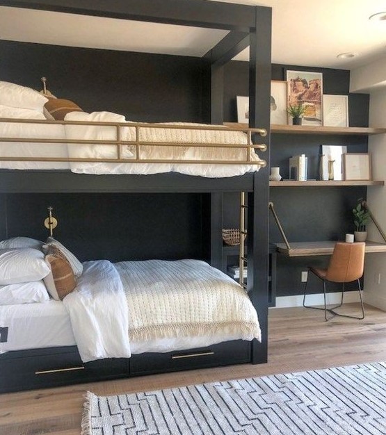 a stylish shared teen boy bedroom with black bunk beds, a folding desk, open shelves and touches of gold