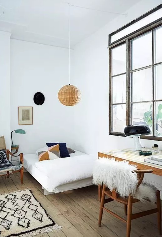 a teen Scandinavian room with a small bed, a desk and a chair, a rattan pendant lamp and a large window with no curtains