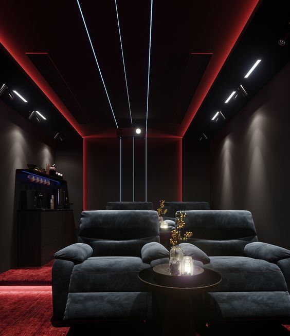 a beautiful moody home theater with black walls, built-in blue and red lights, dark grey seating furniture, red carpets and lights