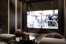 a luxurious and refined home theater done in greys and taupe, with a large screen, built-in lights, a large sofa and some chairs is wow