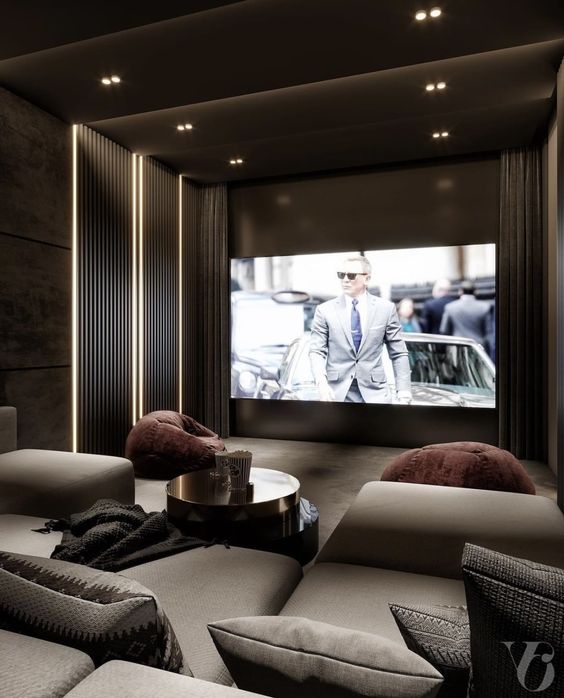 a luxurious and refined home theater done in greys and taupe, with a large screen, built-in lights, a large sofa and some chairs is wow