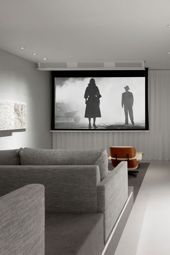 a minimalist home theater with a large screen, grey seating furniture, comfortable chairs and built in lights is a lovely idea