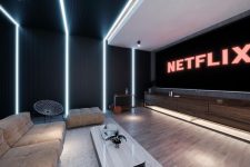 a minimalist home theater with a large screen, tan seating furniture, a chic stone coffee table and built-in lights is a cool space