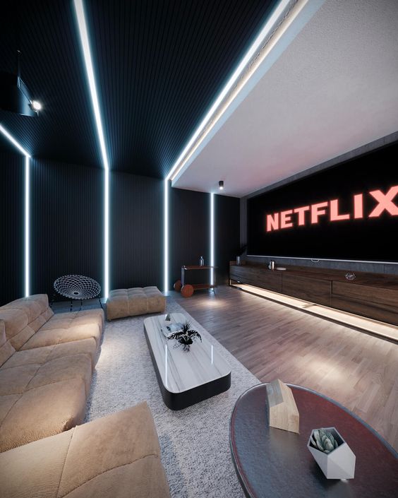 a minimalist home theater with a large screen, tan seating furniture, a chic stone coffee table and built-in lights is a cool space