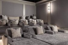 a pretty grey home theater with a starry sky ceiling, comfortable seating furniture with pillows is a lovely space to be
