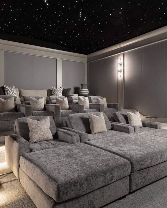 a pretty grey home theater with a starry sky ceiling, comfortable seating furniture with pillows is a lovely space to be