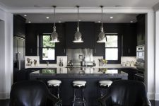 bold dark kitchen deisgn with black cabinetry and white countertops looks well combined with a island with a natural stone coutnertop