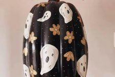 a beautiful painted black Halloween pumpkin with flowers and ghosts is a cool and chic solution