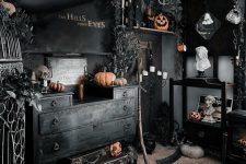 a black Halloween room with a catchy gallery wall, black suitcases, orange pumpkins and black blooms and leaves