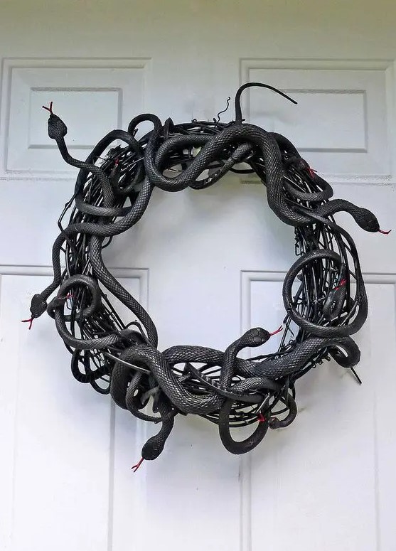 a black vine and faux snake wreath is a fantastic idea for Halloween, make one fast and easily using dollar store supplies