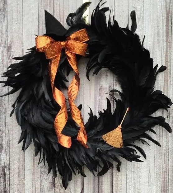 a bright Halloween wreath covered with black feathers, an orange glitter bow and a little broom is a gorgeous idea to rock