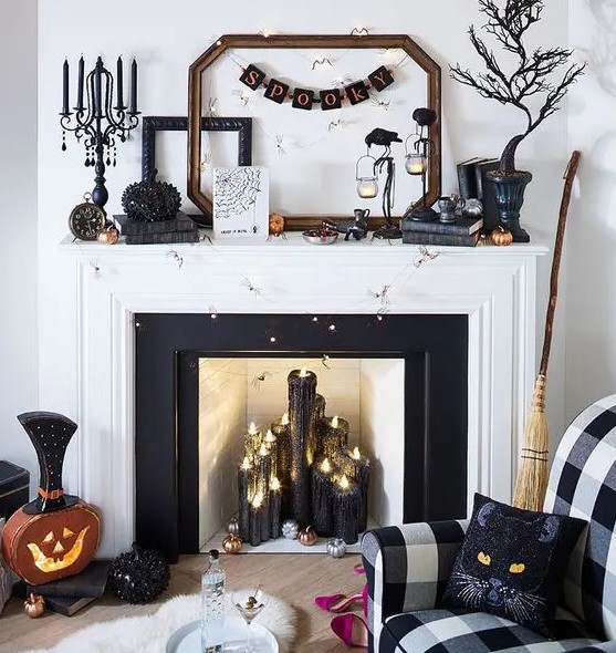 a glam Halloween fireplace with black glitter candles, a spooky tree, a banner, crows, a rhinestone pumpkin, cat pillows and lights