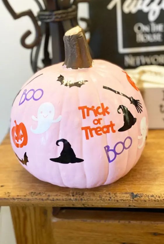 a pink pumpkin with ghosts, pumpkins, bats, witches' hats and brooms plus colorful letters is a cool solution