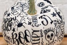 a simple white pumpkin decorated with a black sharpie is a very cute and lovely idea to rock for Halloween