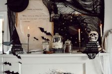 a white piano decorated with black branches and bats, lights, black spider web, hats, bats, candles and other stuff looks amazing