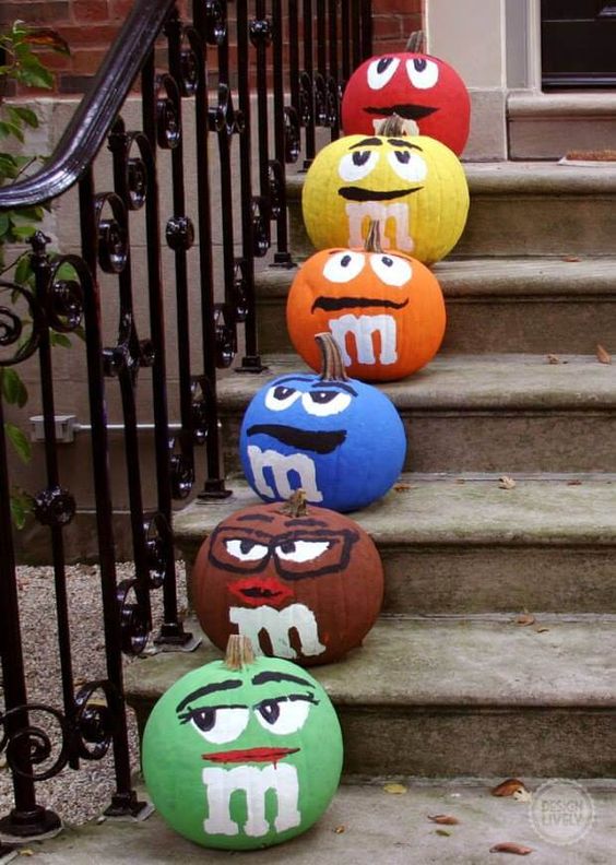 colorful M&Ms pumpkins are a funny and crowd-pleasing idea that will attract attention to your space for sure