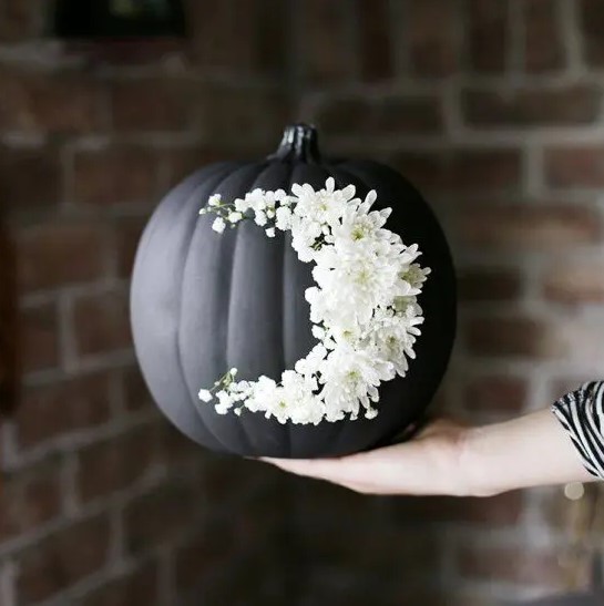 go for creative art decorating your matte black pumpkin with white blooms like that   this isn't a durable decoration but a very cool one