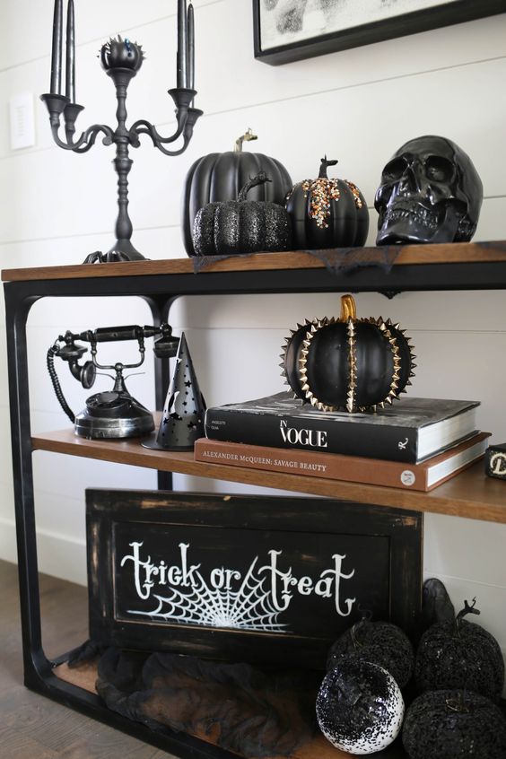 gorgeous Halloween console decor with a sign, some cool black pumpkins with spikes and rhinestones, a black candelabra with black candles