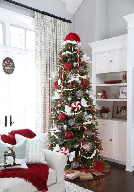 a Christmas tree with lights, red and white ornaments, silver and chalkboard touches plus a Santa cap on top
