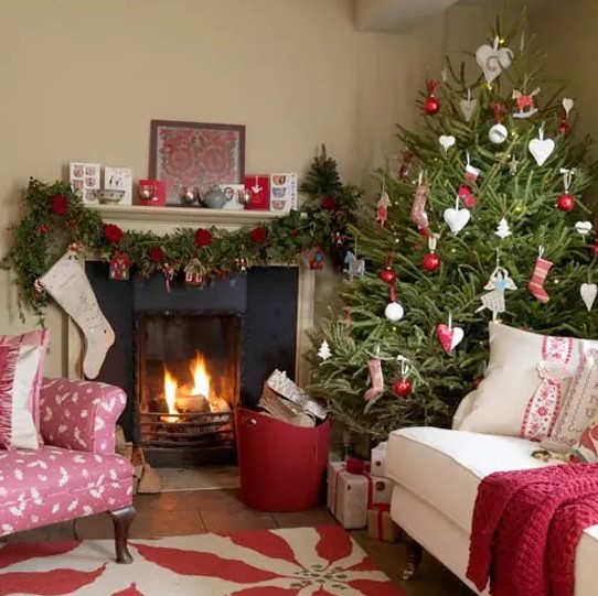 a Christmas tree with red and white ornaments, a garland with red blooms and gift boxes make the space feel Scandinavian and holiday-like