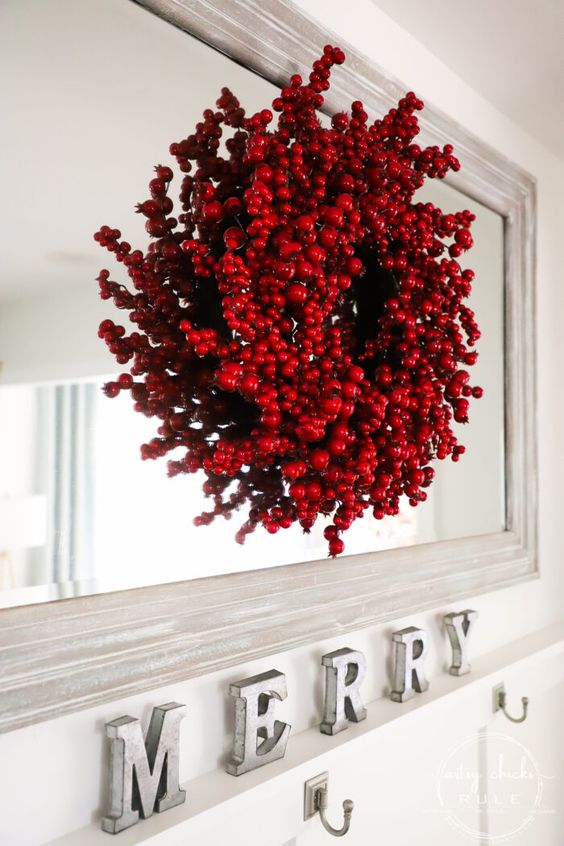 a Christmas wreath composed of red ornaments and faux berries looks very bold, eye-catchy and super cool