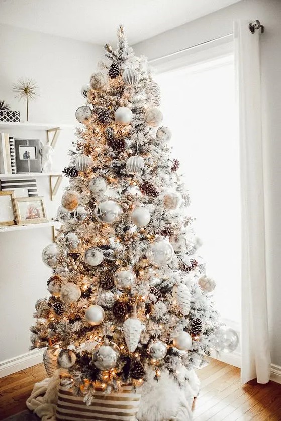 a breathtaking winter wonderland Christmas tree with white and silver ornaments, lights, pinecones and branches is a gorgeous idea