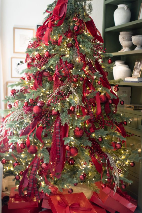 a bright Christmas tree decorated with red ornaments, red ribbons and berries plus lights is amazing for the holidays