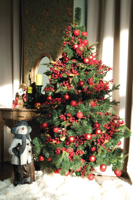 a bright Christmas tree styled with red ornaments and faux berries plus pinecones looks amazing