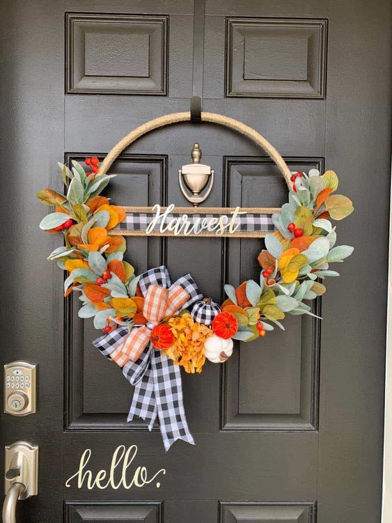 a bright Thanksgiving wreath of a hoop with faux leaves, berries, plaid ribbon and some mini colorful gourds is amazing