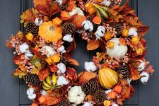 a bright Thanksgiving wreath with pinecones, gourds, pumpkins, leaves and dried blooms is a very eye-catchy solution