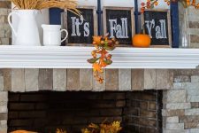 a bright and simple Thanksgiving mantel with wheat in a jug, chalkboard signs, window frames, bold pumpkins and fruits