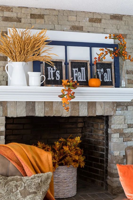 a bright and simple Thanksgiving mantel with wheat in a jug, chalkboard signs, window frames, bold pumpkins and fruits