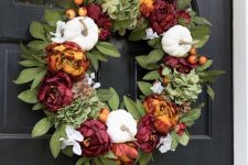 a bright fall or Thanksgiving wreath of leaves, white gourds and bold faux blooms is a stylish and timeless decoration