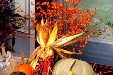 a bucket with hay, corn cobs, gourds, pumpkins and berries is a pretty rustic decoration for fall or Thanksgiving