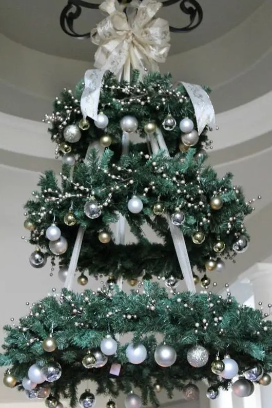 a chandelier made of faux evergreen wreaths and silver and gold ornaments is a gorgeous Christmas decoration