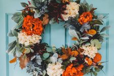 a colorful fall or Thanksgiving wreath with orange, burgundy and white blooms, greenery and foliage is amazing