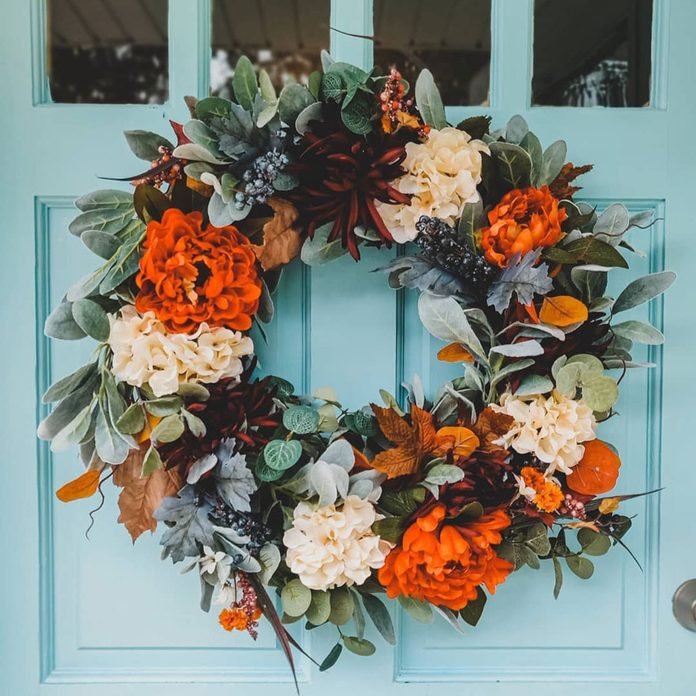 a colorful fall or Thanksgiving wreath with orange, burgundy and white blooms, greenery and foliage is amazing