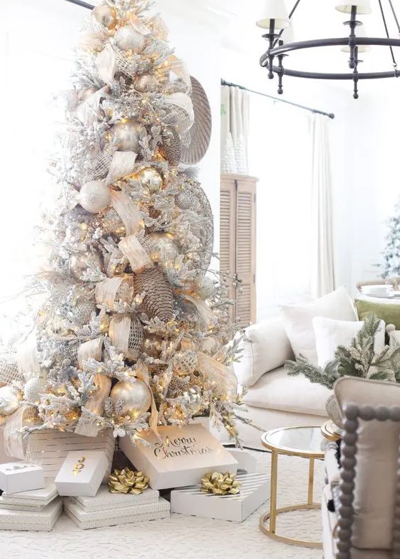 a fantastic winter wonderland Christmas tree with silver and pearl ornaments, lights, snowy berries and branches, oversized pinecones